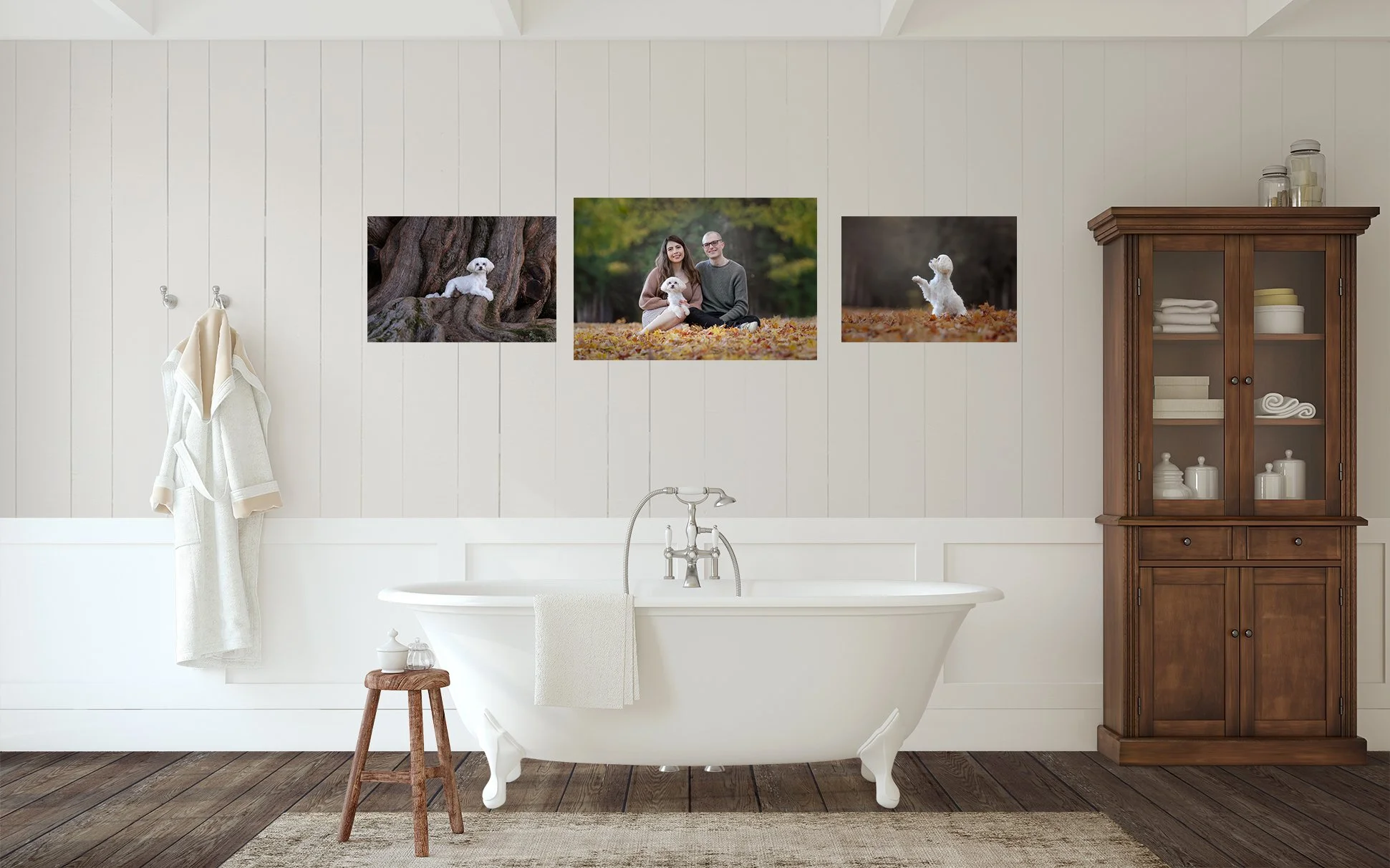 A rustic bathroom with a white bathtub, a wooden stool, and a tall wooden cabinet. Three photos of small white dogs in outdoor settings are framed on the wall above the tub.